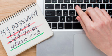 A hand types on a laptop keyboard next to a notepad showing crossed-out weak passwords and a highlighted strong password: "uFree!!!=3", reminding users of tips for avoiding scams on verification-free gambling sites. | eCryptoBit